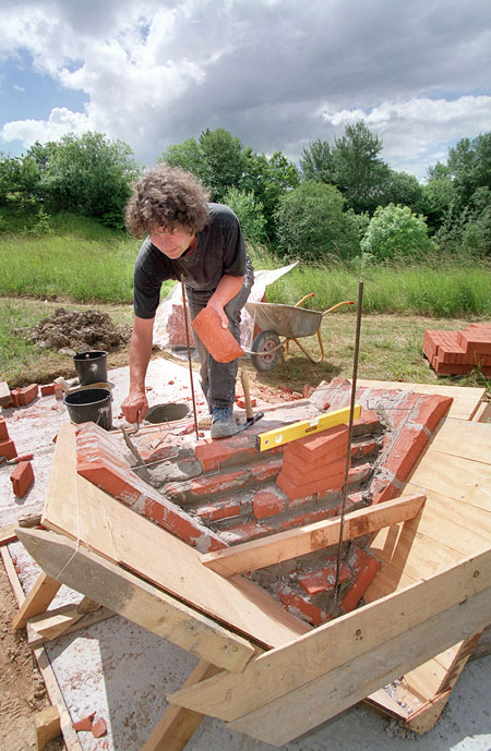 The artist working on the brick sculpture