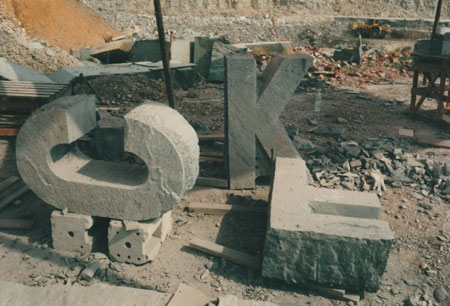 Zwischenzustand der roh bearbeiteten vier Buchstaben für 'Instant Archetypes'im Steinbruch